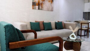 A modern living room with a sofa, chairs, and a glass coffee table.