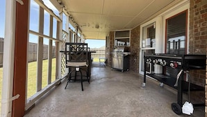 Un patio techado al aire libre con una parrilla y una estación de barbacoa.