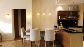 Une cuisine moderne dotée d’un îlot central, de luminaires suspendus et d’un parquet disposé en motif à chevrons.