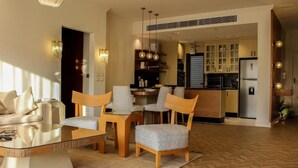 Un salon moderne avec une table basse en verre, des chaises en bois et un canapé.