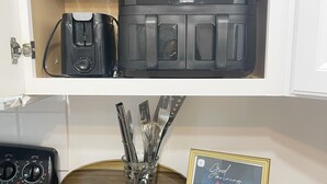 A kitchen with a toaster, a coffee maker, and a framed picture on the counter.
