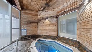 Un spa con jacuzzi, paredes de madera y suelo de baldosas.