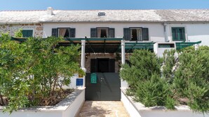 A building with a stone facade, green shutters, and a covered entrance.
