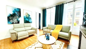 Ein Wohnzimmer mit zwei Sofas, einem Couchtisch und Kunstwerken an den Wänden.