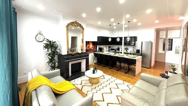 Ein modernes Wohnzimmer mit Kamin, Essbereich und Küche.