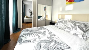 Ein Schlafzimmer mit Bett, Nachttisch, Spiegel und einem Bild an der Wand.