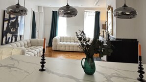 A modern living room with a sofa, a coffee table, and pendant lights. - Luxury Capitol 122m² Air-conditioned - Parking & Elevator & Subway (Toulouse)