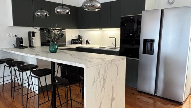 A modern kitchen with a central island, stainless steel appliances, pendant lighting, and wooden flooring. - Luxury Capitol 122m² Air-conditioned - Parking & Elevator & Subway (Toulouse)