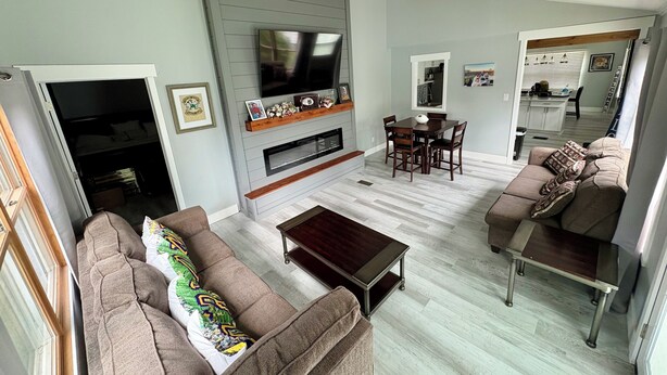 A living room with a TV, sofa, coffee table, and dining area. - RARE CHANCE TO RENT THIS ND HOME 1.45 MILES FROM ND CAMPUS WITH IRISH PUB & MORE (South Bend)