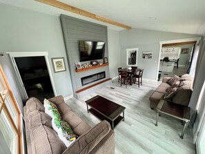 A living room with a TV, sofa, coffee table, and dining area. - RARE CHANCE TO RENT THIS ND HOME 1.45 MILES FROM ND CAMPUS WITH IRISH PUB & MORE (South Bend)