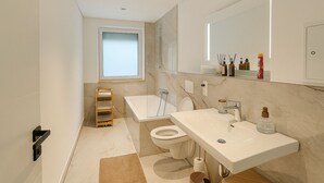 Une salle de bain moderne avec une baignoire, des toilettes et un lavabo.
