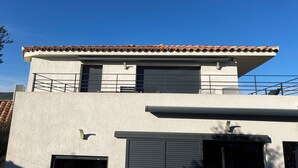 A modern building with a flat roof, large windows, and a balcony. - New T3 apartment near the sea / port / large terrace / parking (Sanary-sur-Mer)