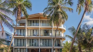 A multi-story hotel with balconies, large windows, and palm trees. - Kinan Boutique (Fulidhoo)