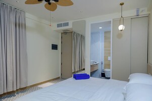 Una habitación de hotel con cama, baño y armario.