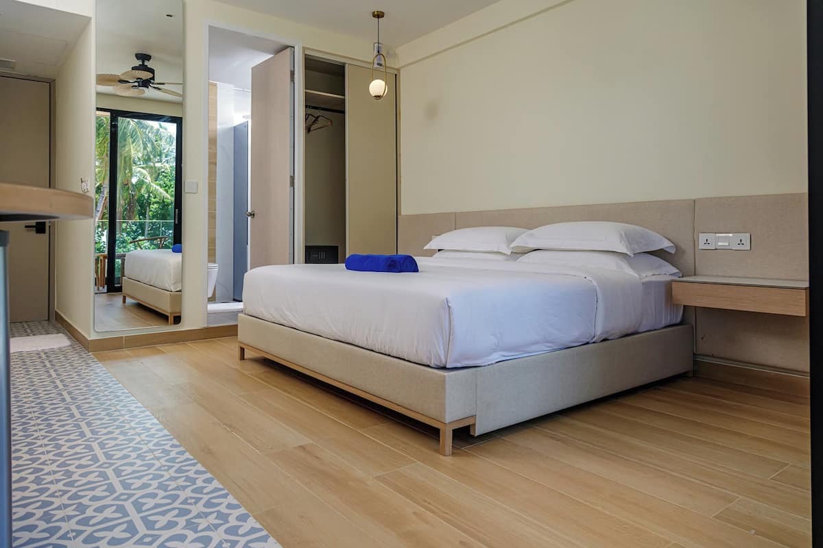 Un dormitorio moderno con una cama grande, un ventilador de techo y vistas al exterior.