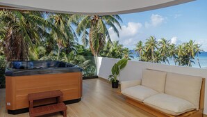 A balcony with a hot tub, a sofa, and a potted plant. - Kinan Boutique (Fulidhoo)
