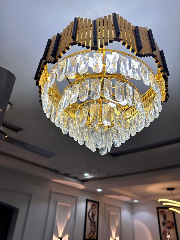 A chandelier with multiple tiers of clear crystals and gold accents.