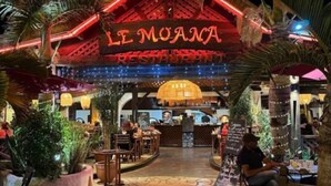 A restaurant named "LE MOANA" with a tropical theme, featuring a thatched roof and palm trees.