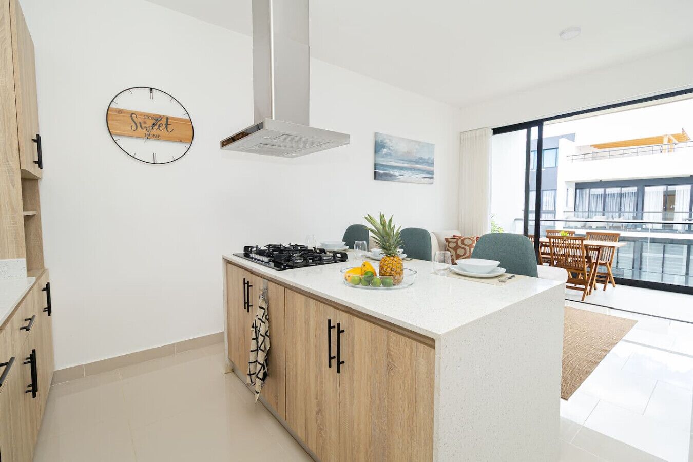 A modern kitchen with a central island, a gas stove, and a hanging pot rack.