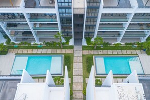 A modern building with two swimming pools, a rooftop terrace, and a view of the surrounding area. - Spacious 3BD Penthouse Private Rooftop Sea Breeze (San Rafael del Yuma)