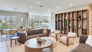 A spacious living area with a sectional sofa, round coffee table, and a bookshelf with decorative items. - Naples Waterfront 3 Master en-suites Pool Boat lift (Naples)