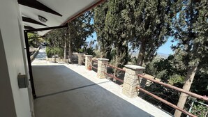 A concrete pathway with stone railings and a view of trees and a distant landscape. - Monolithos Cottage in the Troodos Mountains above Limassol (Pachna)