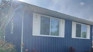 A single-story house with a blue exterior and white window shutters. - Longfellow Tides (Lexington)