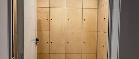 A room with a tiled floor, wooden panel walls, and a door with a handle.