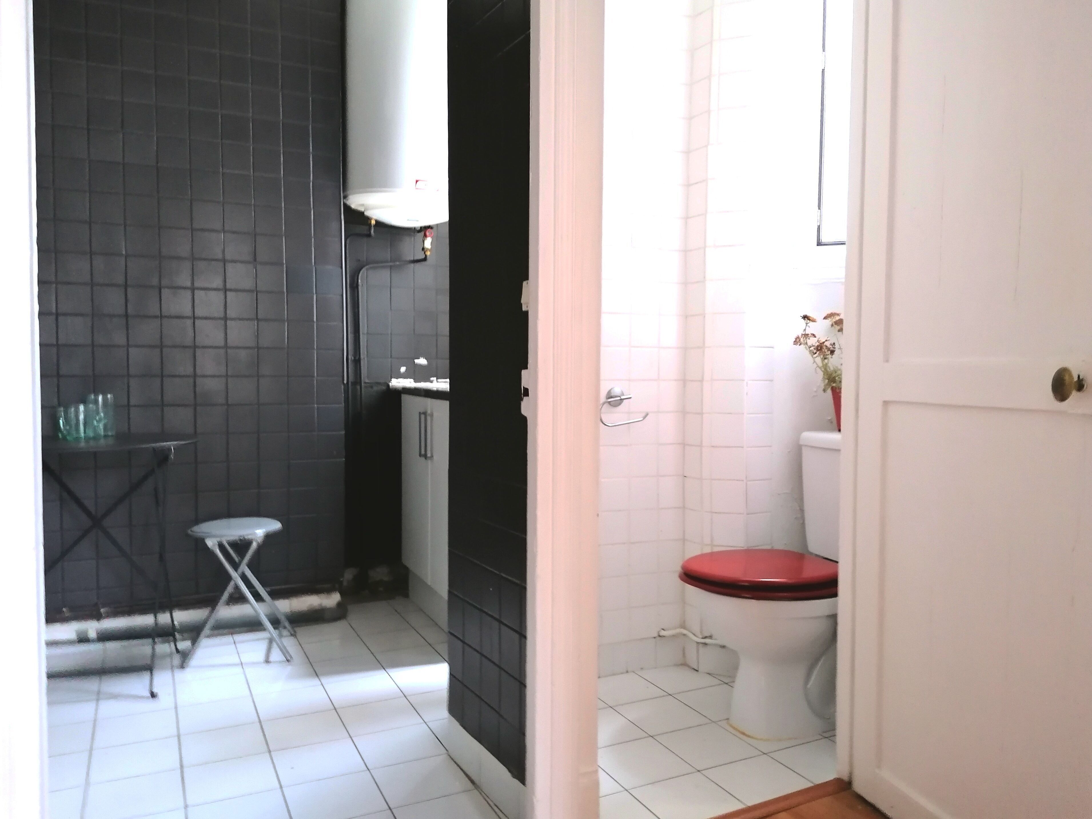 A bathroom with a toilet, sink, and shower area.