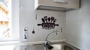 A kitchen with a stainless steel sink, a window, and a decorative backsplash with kitchen utensils. - Spacious apartment in central area with balcony, within walking distance of Scassi Hospital (Genova)