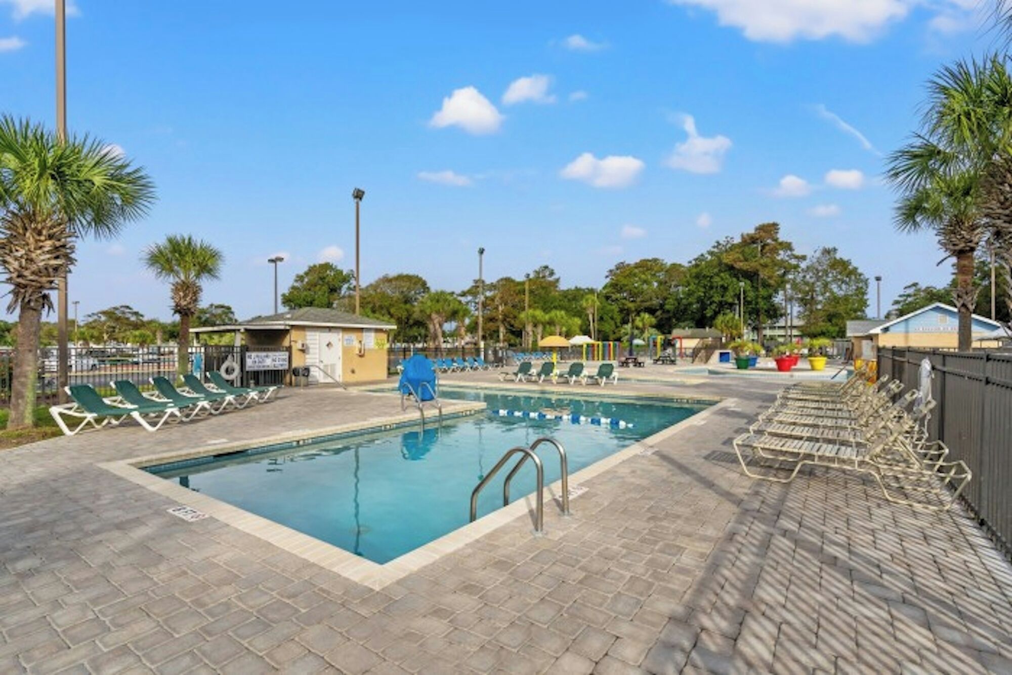 Una piscina con sillas de descanso y una estación de salvavidas.