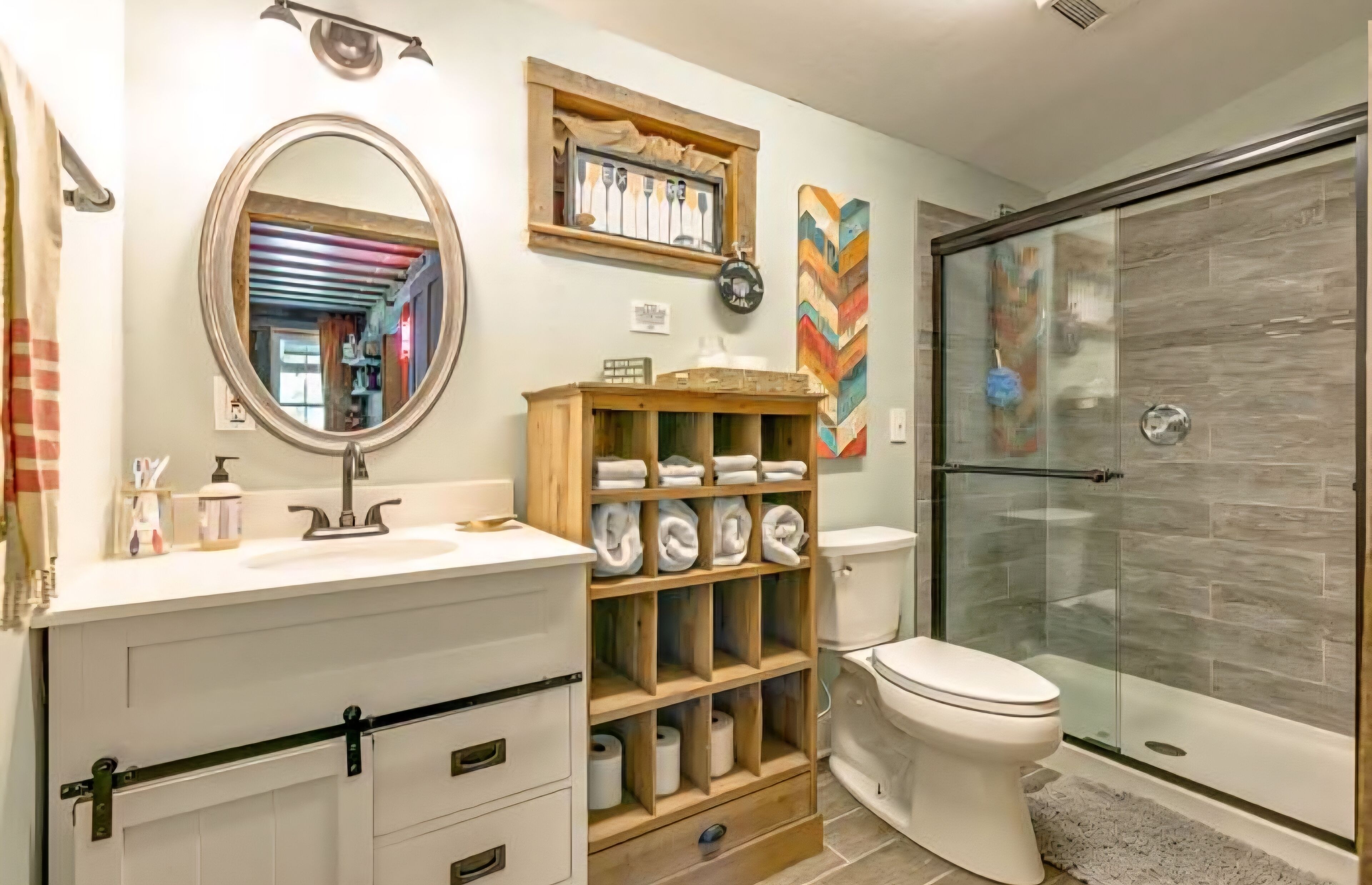A modern bathroom with a shower, a wooden towel rack, a mirror, and a toilet.