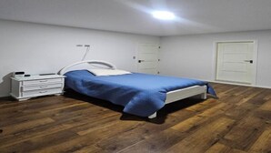 A bedroom with a bed, a dresser, and a door. - one-bedroom apartment (Cochabamba)