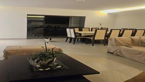 A modern living room with a dining area, a sofa, and a coffee table with a plant. - one-bedroom apartment (Cochabamba)