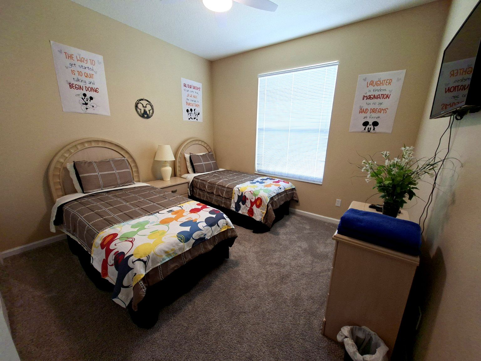 Een slaapkamer met twee bedden, een raam en motiverende posters aan de muur.