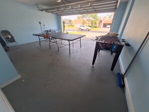 A room with a ping pong table, a foosball table, and a chair. - Luxury Villa - Family Oasis with Private Pool - close to Disney and Universal! (Clermont)