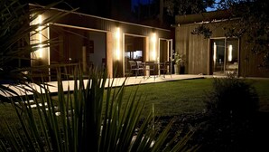 Une maison moderne dotée d’un patio, d’une table à manger et de chaises.