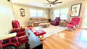 A spacious living room with a beige sofa, a red armchair, and a coffee table. - Secluded Farmhouse Retreat - Groups & Pets Okay! (Turkey)