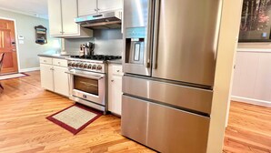 A kitchen with stainless steel appliances, wooden flooring, and light-colored cabinetry. - Secluded Farmhouse Retreat - Groups & Pets Okay! (Turkey)