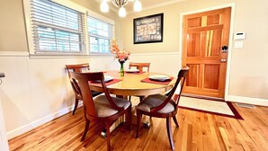 A dining room with a wooden table, four chairs, a chandelier, and a door with a picture frame on the wall. - Secluded Farmhouse Retreat - Groups & Pets Okay! (Turkey)