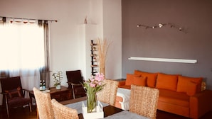 A living room with a sofa, chairs, a table, and a vase of flowers. - Luxury Retreat in Franciacorta (Villa Pedergnano)