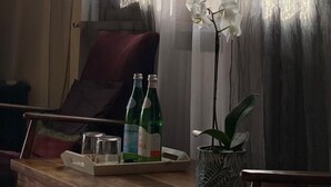 A wooden table with two bottles of water, a glass, and a tray. - Luxury Retreat in Franciacorta (Villa Pedergnano)