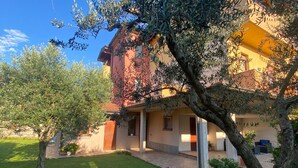 A two-story building with a covered patio area and a small garden. - Luxury Retreat in Franciacorta (Villa Pedergnano)