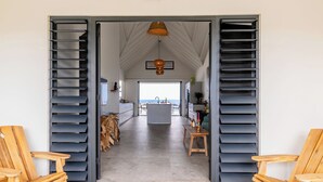 An open doorway leading to a spacious kitchen with a view of the sea.