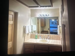 Une salle de bain équipée d’un lavabo, d’un miroir et d’un porte-serviettes.