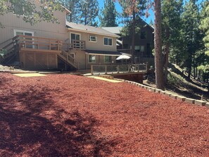 Un quartier résidentiel avec une maison dotée d’une terrasse en bois et d’un espace extérieur aménagé et couvert.