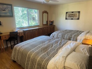 Ein Schlafzimmer mit einem Bett, einem Schreibtisch und einem Fenster.