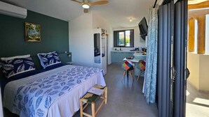 A bedroom with a bed, a desk, a chair, a ceiling fan, and a window. - Apartment Joly brise 4 in Terre Sainte near small beach/CHU (Saint-Pierre)