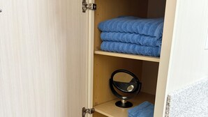 A wooden cabinet with a mirror and folded towels. - Tranquil 2-bedroom apartment in Jacksonville (Jacksonville)