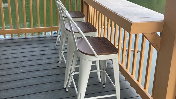 A wooden deck with a table and two chairs overlooking a lake. - Charming 2-bedroom house boat in Norris Lake. (Speedwell)